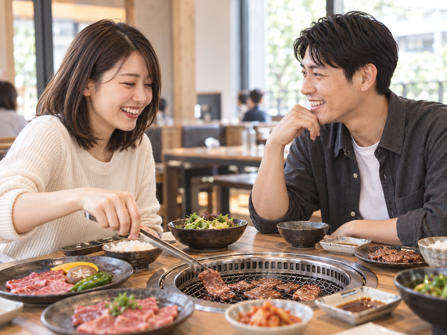 お店で焼肉と食事を囲み、ふたりが自然に会話を楽しむ様子。
